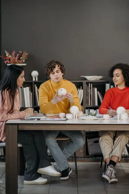 about-us Des membres de l’équipe échangent sur des graphiques numériques sur une tablette dans un bureau moderne.